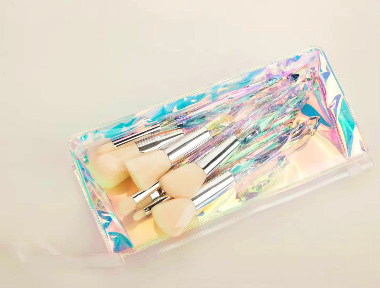 10-piece vegan makeup brush set with iridescent, crystal-style handles, contained in a clear, holographic carrying case.