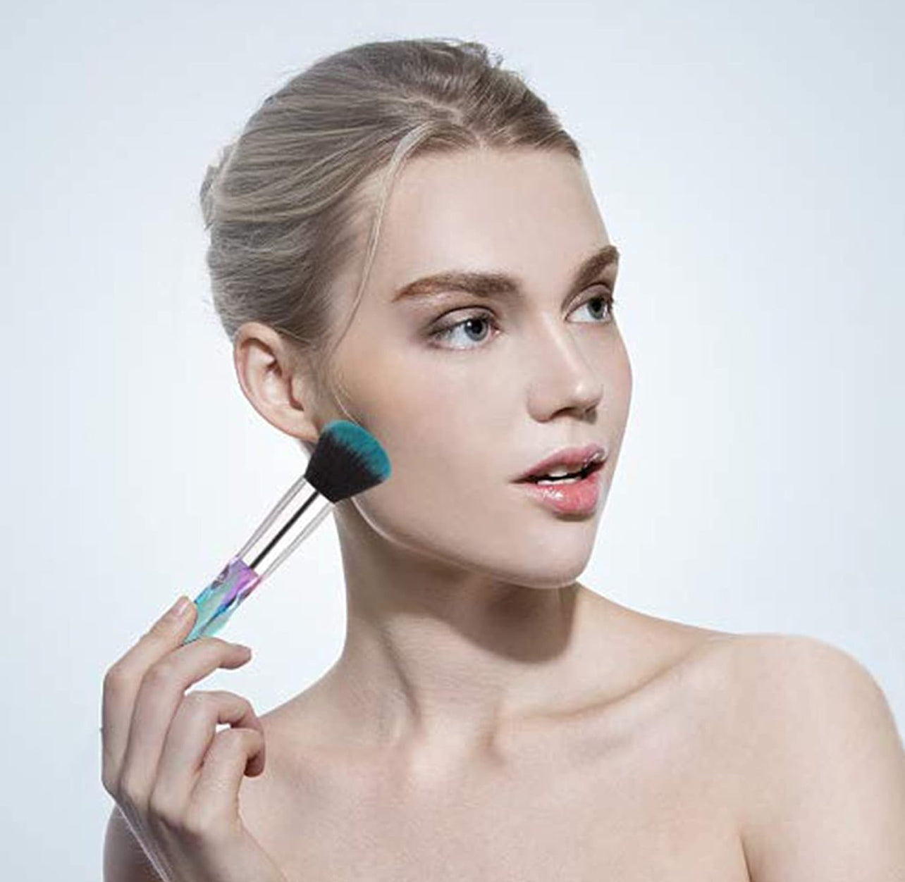 10-piece vegan makeup brush set with iridescent, crystal-style handles, contained in a clear, holographic carrying case.